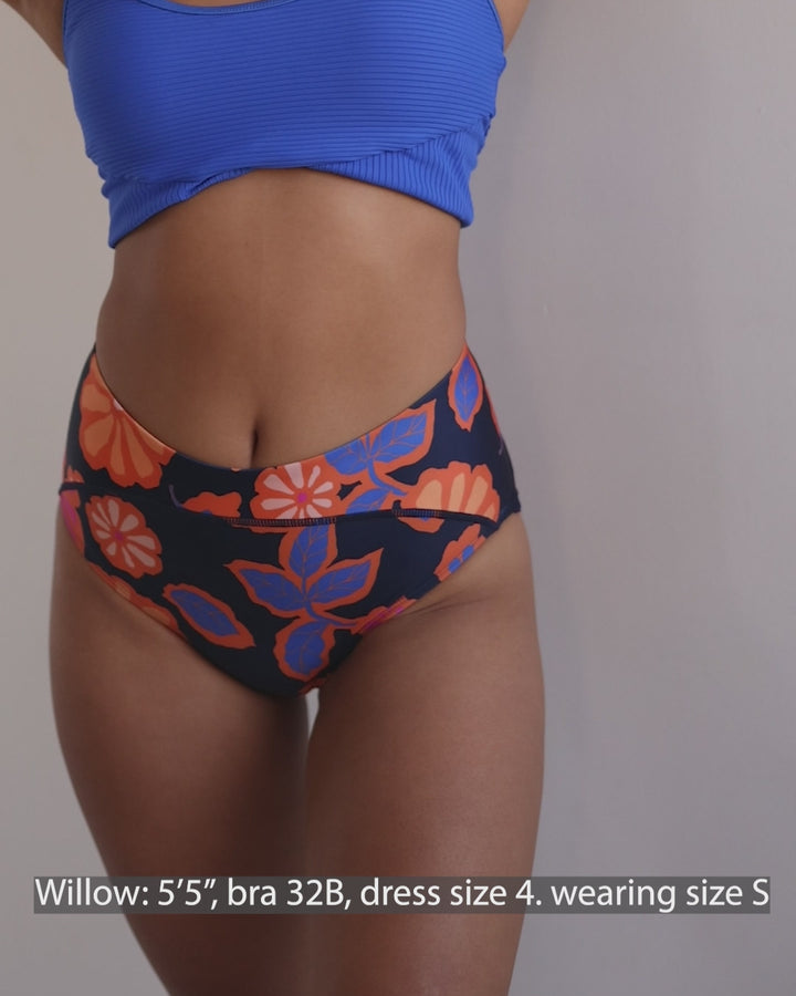Video showing bright orange, blue and pink floral swimsuit bottoms