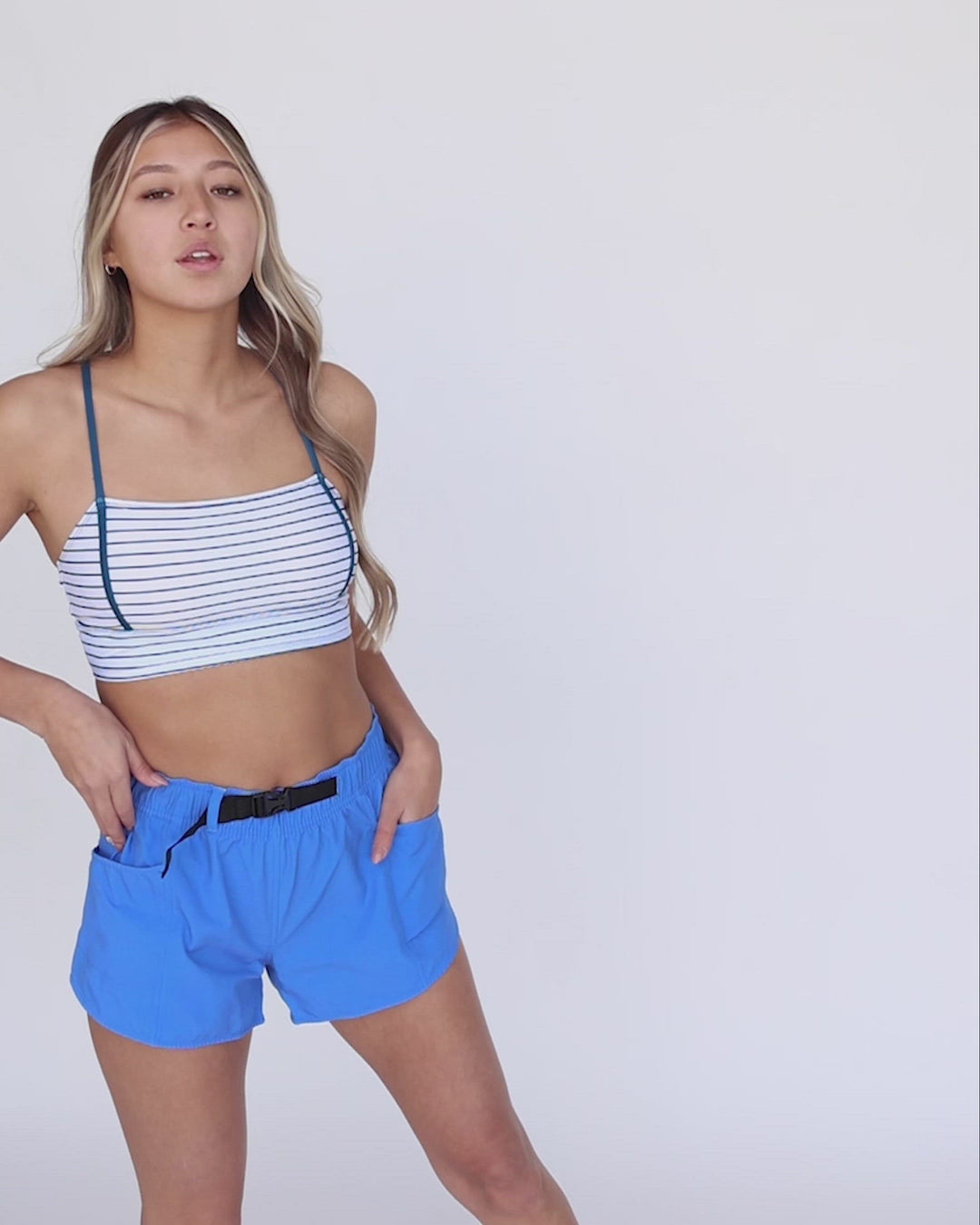 A video of a women modeling blue exercise shorts.