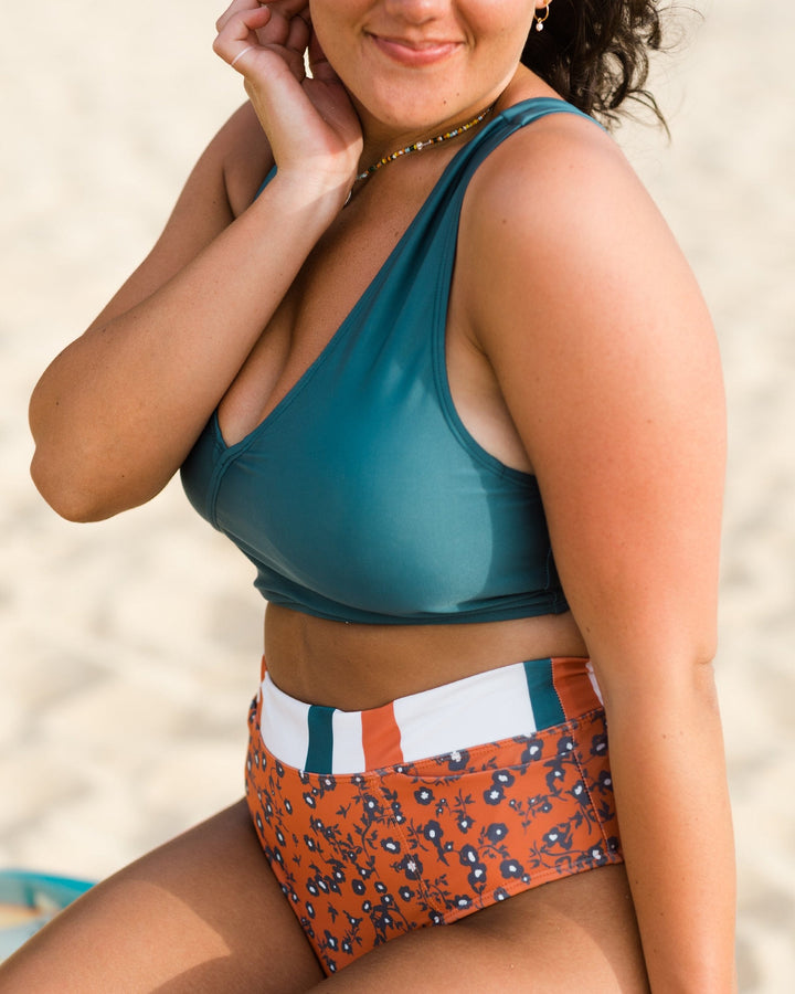 Close up photo of a women wearing a blue swimsuit top. 