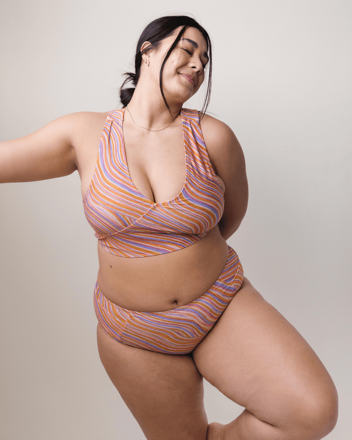 Front View studio picture of a girl wearing a retro pink, blue, purple and orange wave Yoga Pocket Bottom