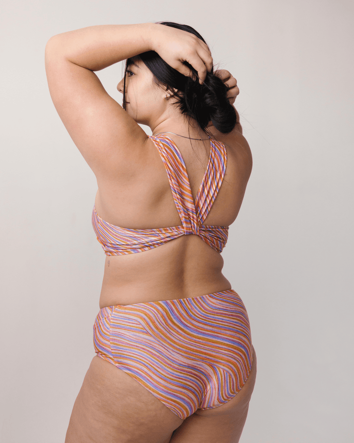 Back View studio picture of a girl wearing a retro pink, blue, purple and orange wave Yoga Pocket Bottom