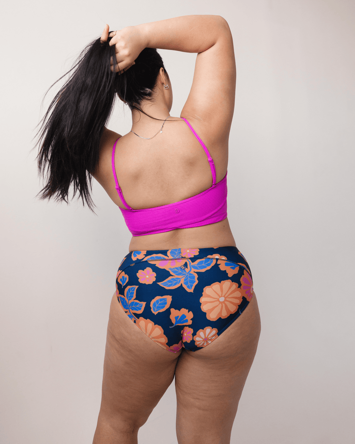 Back View studio picture in floral swimsuit bottoms and pink bikini top