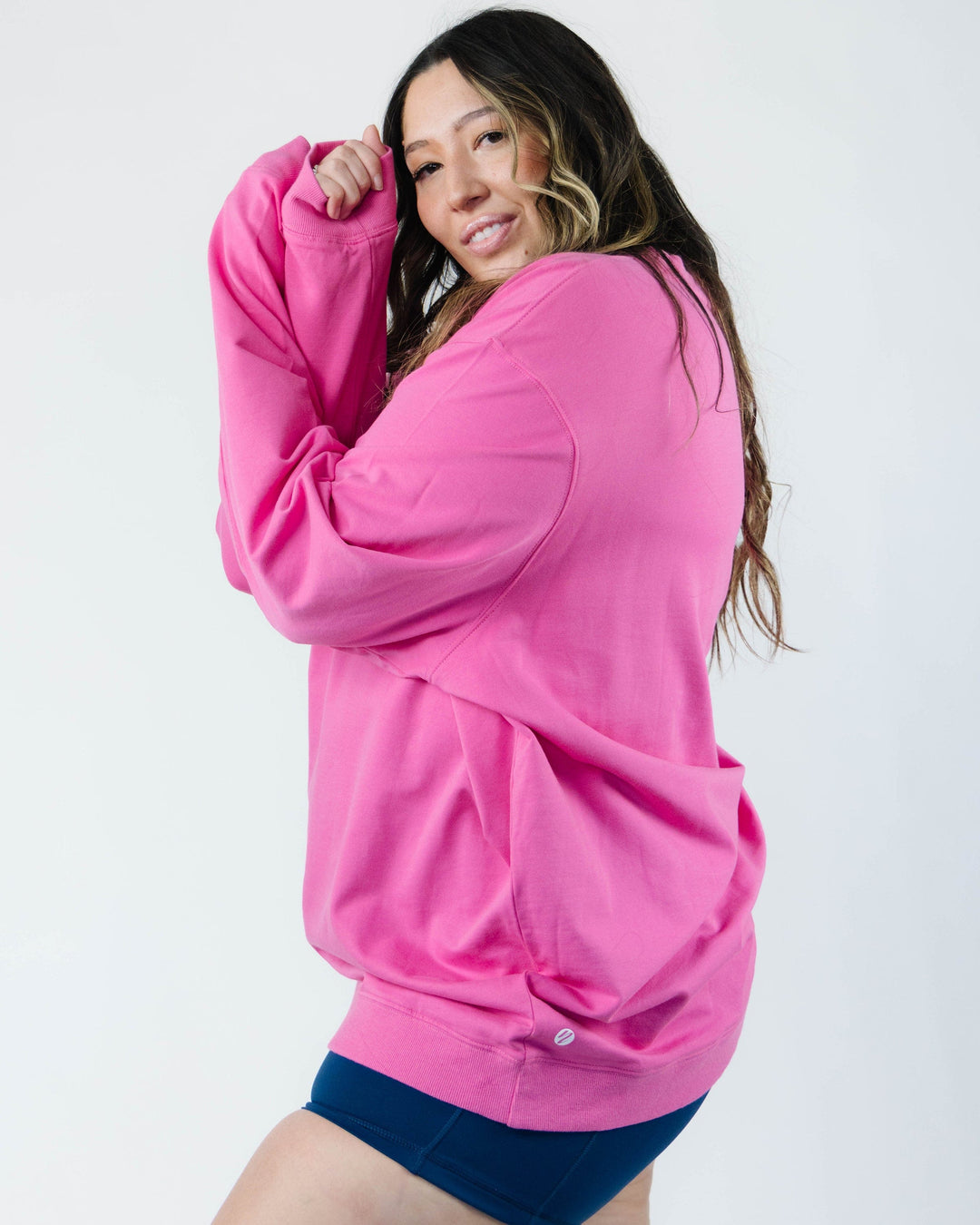 A women modeling a hot pink crewneck sweatshirt.