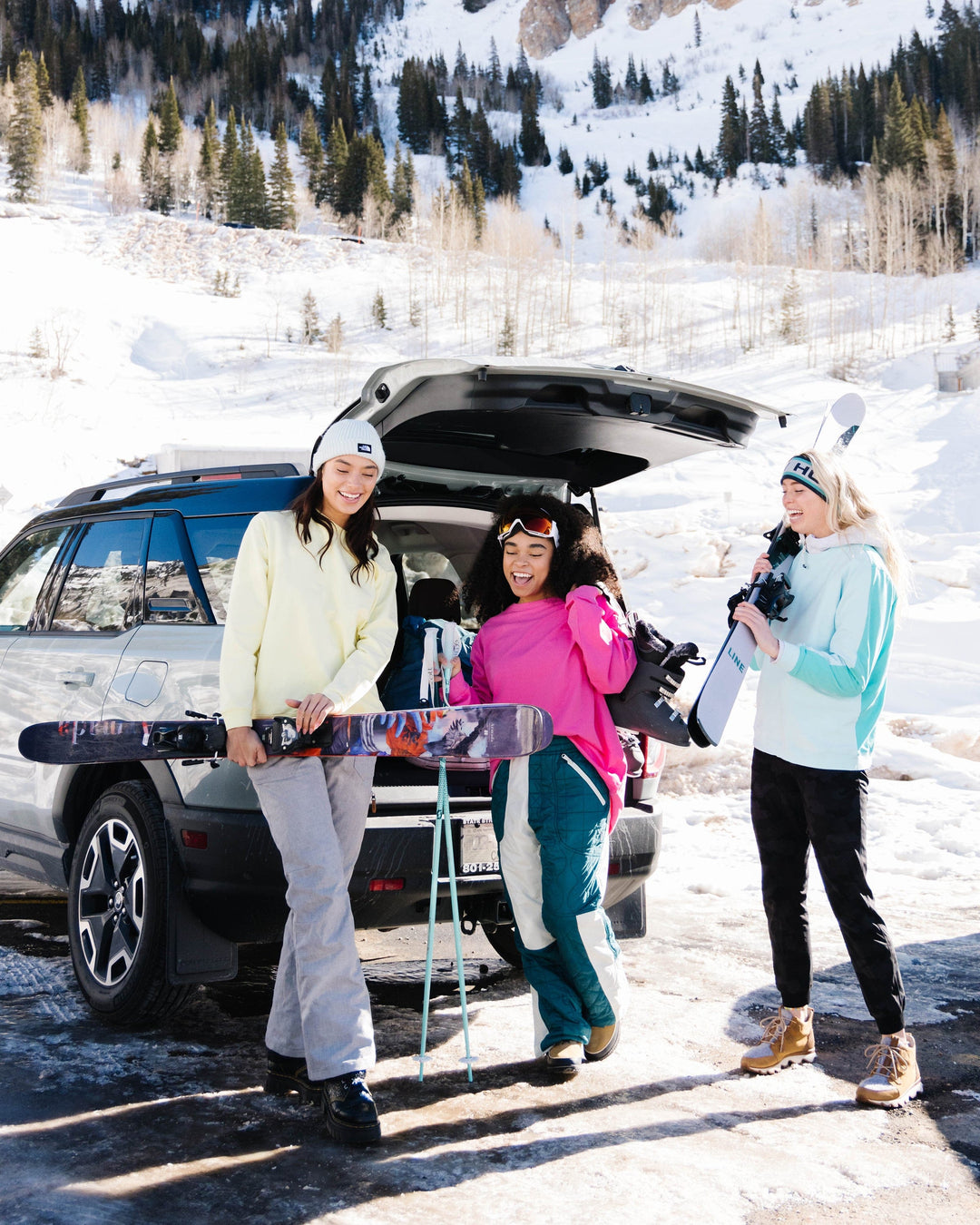 A group of women preparing to go skiing in colorful crewneck sweatshirts.