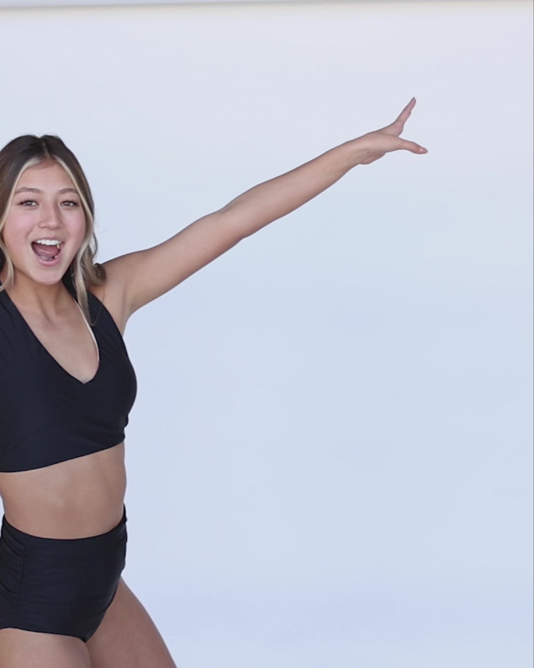 A video of a confident you women modeling black high waisted swimsuit bottoms.